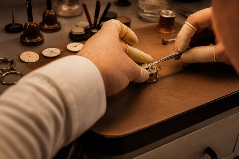 Uhrmachermeister bei der Reparatur eines Uhrwerks in der Bradler Werkstatt